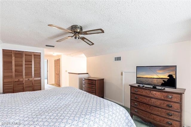 carpeted bedroom featuring a ceiling fan, a closet, visible vents, and a textured ceiling