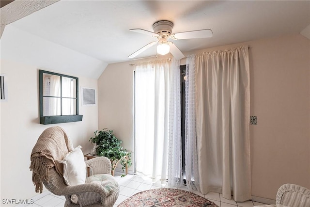 sitting room with lofted ceiling, ceiling fan, light tile patterned floors, and visible vents