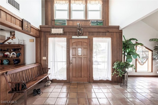 entrance foyer featuring baseboards, visible vents, and a high ceiling