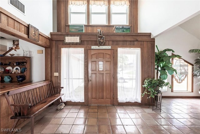 foyer entrance with visible vents, plenty of natural light, and a towering ceiling