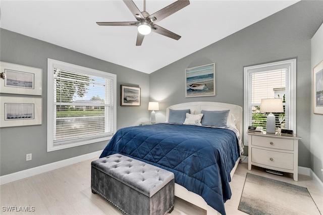 bedroom featuring a ceiling fan, vaulted ceiling, light wood finished floors, and baseboards