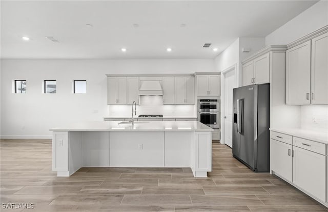 18372 Ridgeline Dr, Estero, FL 33928 - kitchen featuring light countertops, custom range hood, decorative backsplash, appliances with stainless steel finishes, and a sink