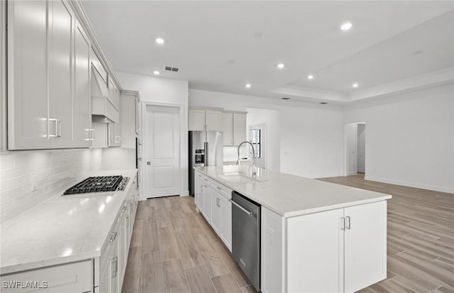 18372 Ridgeline Dr, Estero, FL 33928 - kitchen featuring light wood-style flooring, a sink, visible vents, appliances with stainless steel finishes, and decorative backsplash