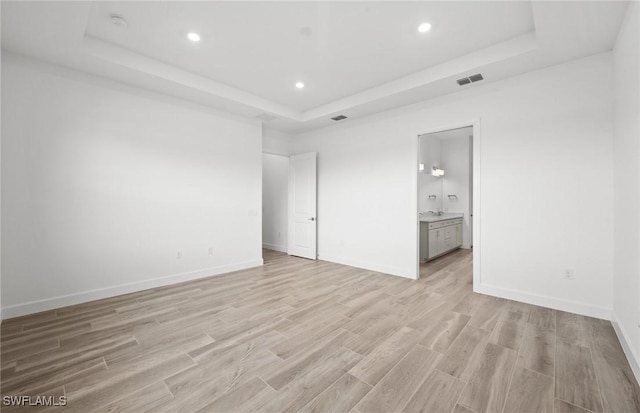 18372 Ridgeline Dr, Estero, FL 33928 - unfurnished bedroom featuring recessed lighting, a raised ceiling, visible vents, light wood-style floors, and baseboards
