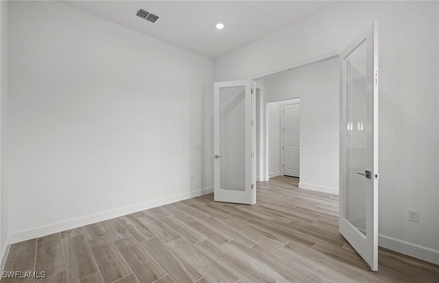 18372 Ridgeline Dr, Estero, FL 33928 - unfurnished bedroom with light wood-type flooring, french doors, visible vents, and baseboards