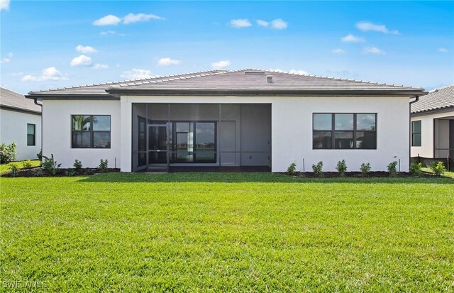 18372 Ridgeline Dr, Estero, FL 33928 - back of house with stucco siding, a sunroom, and a yard