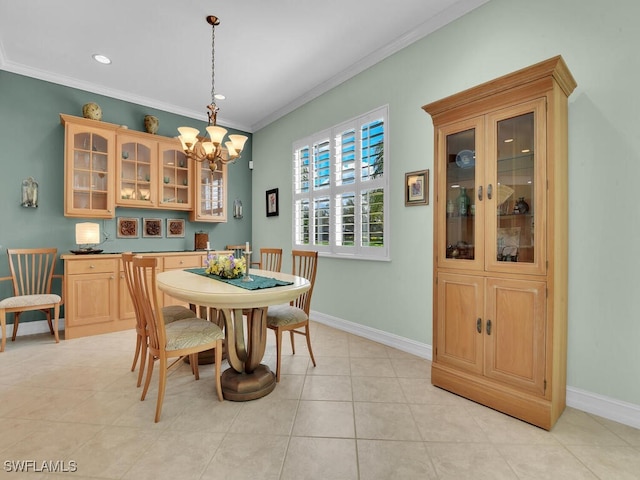 dining area with ornamental molding, baseboards, and an inviting chandelier