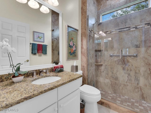 full bath featuring vanity, a tile shower, and toilet