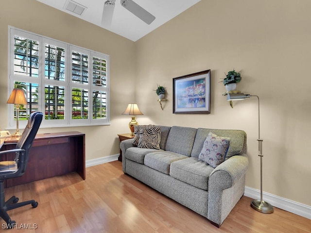 office space with a ceiling fan, visible vents, baseboards, and wood finished floors