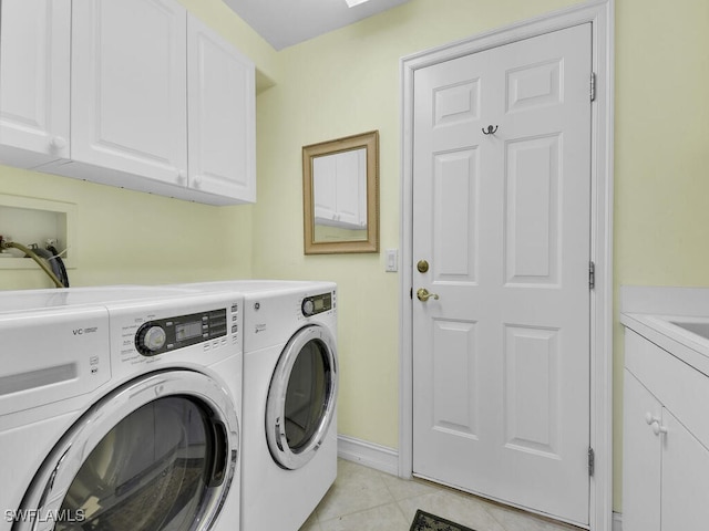 laundry area featuring cabinet space, light tile patterned floors, baseboards, and washer and clothes dryer