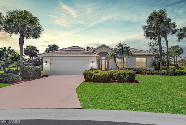 view of front of property featuring concrete driveway, a tile roof, an attached garage, a front lawn, and stucco siding