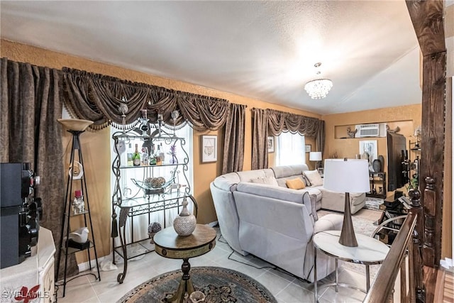 living area featuring a wall unit AC, a chandelier, and light tile patterned flooring