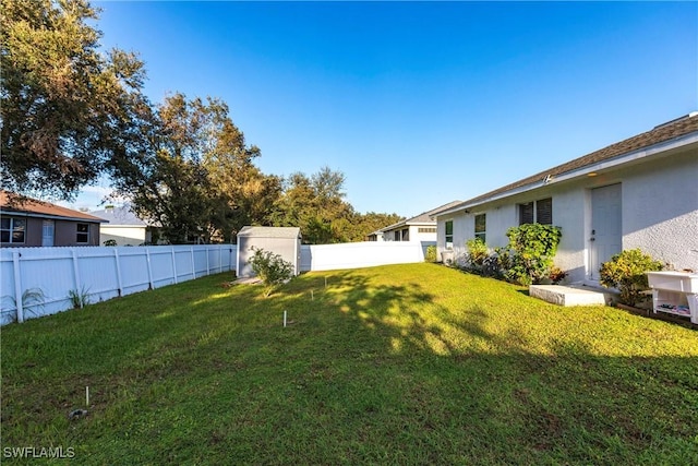 view of yard with a fenced backyard and a shed