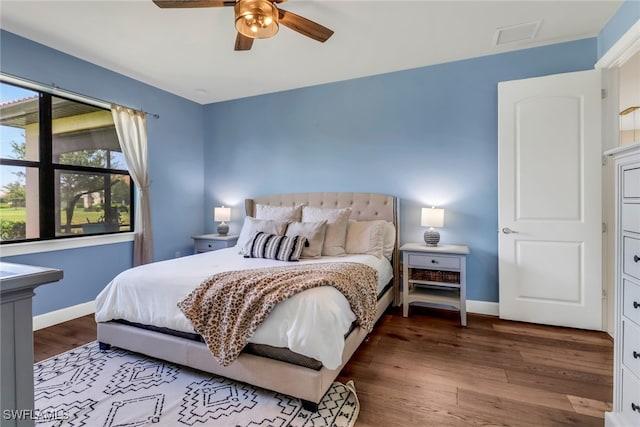 bedroom with ceiling fan, baseboards, and wood finished floors