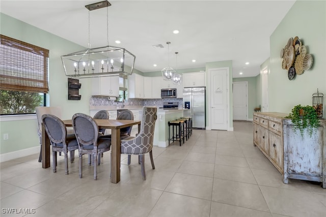 dining space with recessed lighting, an inviting chandelier, baseboards, and light tile patterned floors