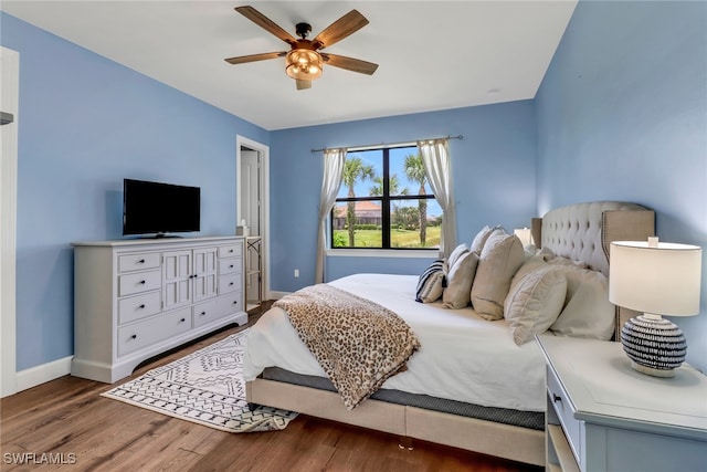 bedroom with ceiling fan, baseboards, and dark wood finished floors