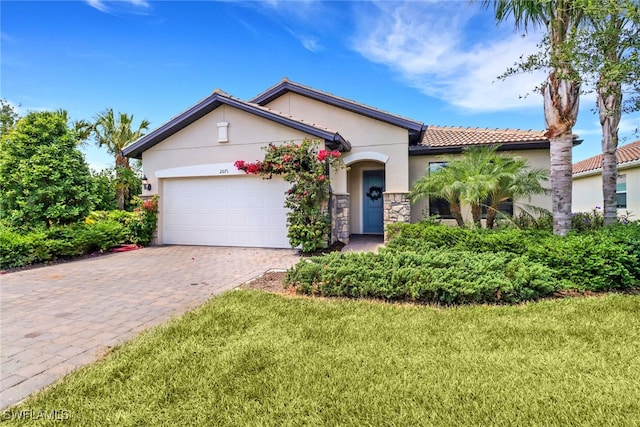 view of front facade with an attached garage, a front yard, decorative driveway, and stucco siding