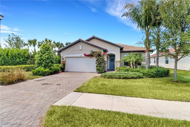 view of front facade featuring a garage, stucco siding, a tile roof, decorative driveway, and a front yard