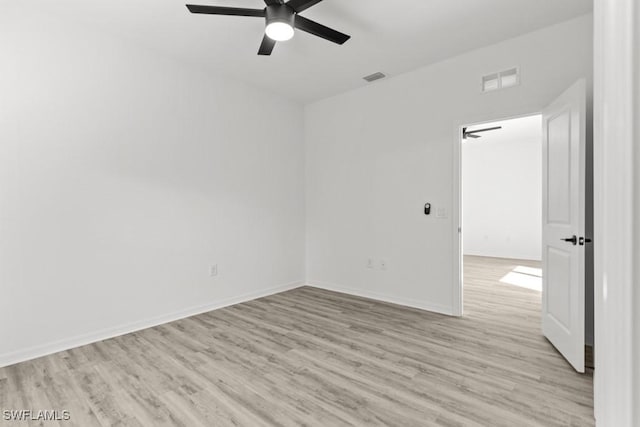 unfurnished room with light wood finished floors, baseboards, and visible vents