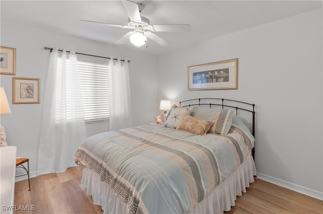 bedroom featuring light wood-style flooring, a ceiling fan, and baseboards