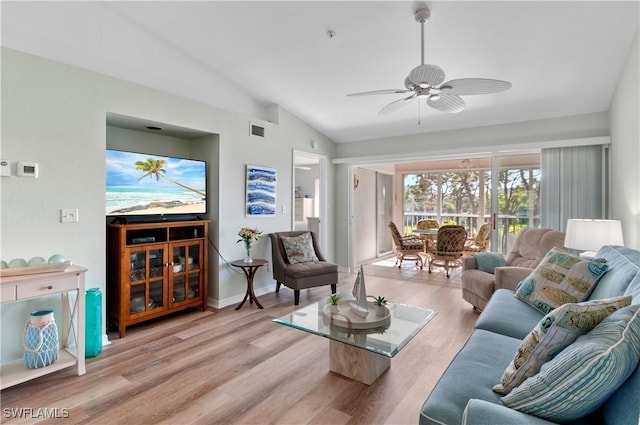 living area with visible vents, a ceiling fan, wood finished floors, baseboards, and vaulted ceiling