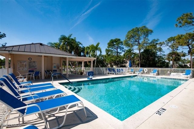 pool with a patio and fence