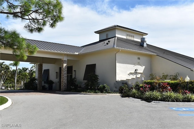 exterior space featuring stucco siding, metal roof, and a standing seam roof