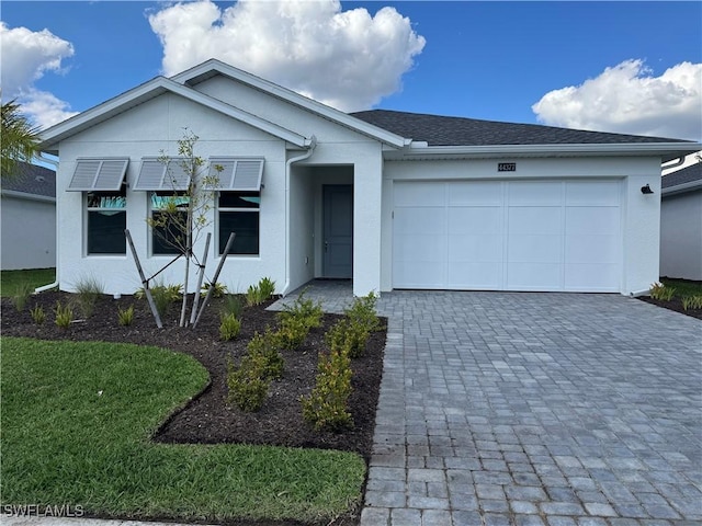 ranch-style house featuring a garage, roof with shingles, decorative driveway, and stucco siding