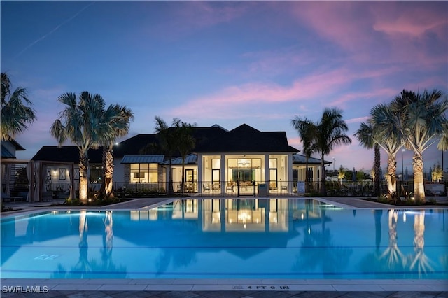 community pool with a patio and fence