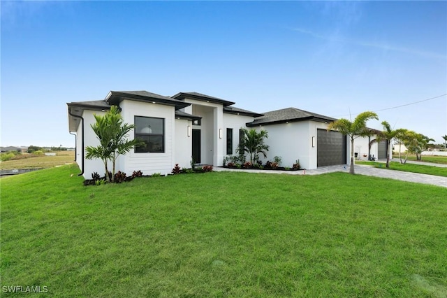 prairie-style home featuring a front yard, driveway, an attached garage, and stucco siding