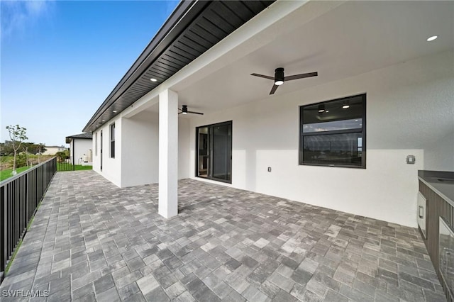 view of patio featuring a ceiling fan and a balcony