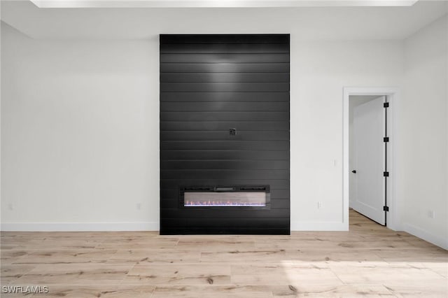 room details featuring a fireplace, wood finished floors, and baseboards