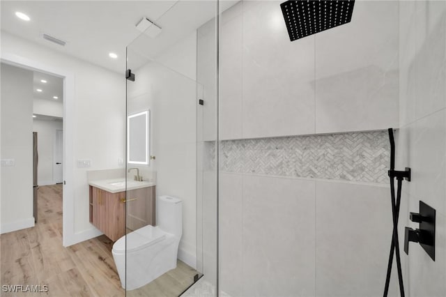 full bathroom with toilet, wood finished floors, visible vents, vanity, and tiled shower