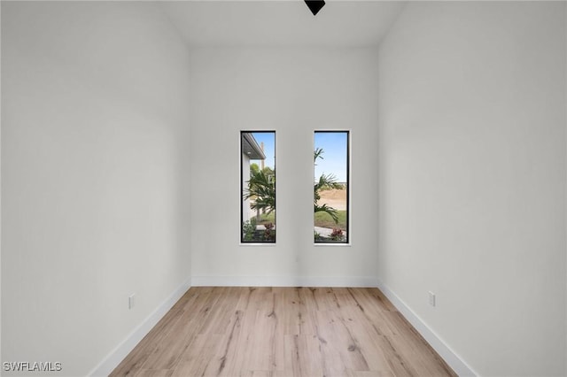 empty room featuring light wood finished floors and baseboards