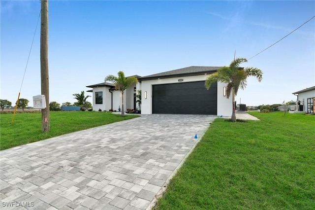 view of front of property featuring an attached garage, central air condition unit, decorative driveway, and a front yard