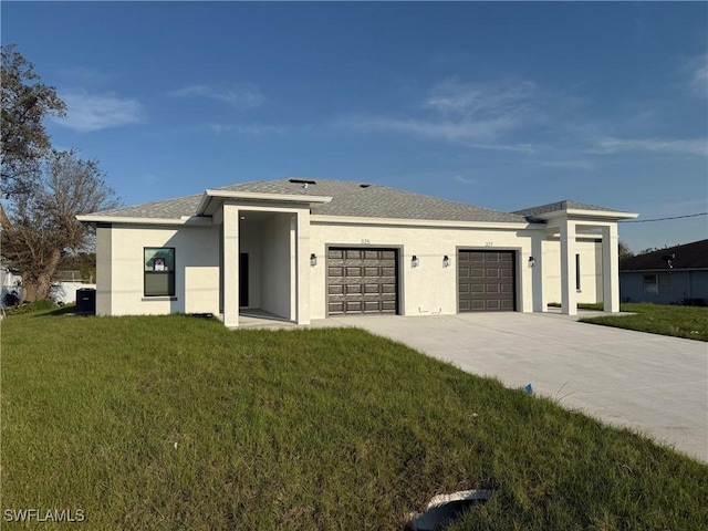 prairie-style house with an attached garage, cooling unit, driveway, stucco siding, and a front yard