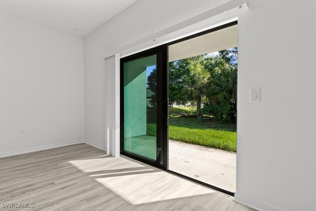 325/327 Harold Ave S, Lehigh Acres, FL 33973 - doorway to outside featuring baseboards and wood finished floors