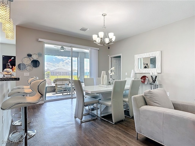 dining area with dark wood-style floors, a textured ceiling, a chandelier, and visible vents