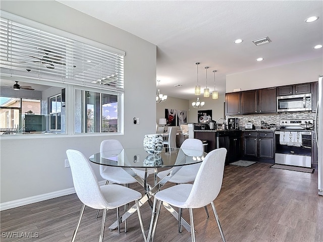 dining area with dark wood-style floors, visible vents, baseboards, and ceiling fan with notable chandelier