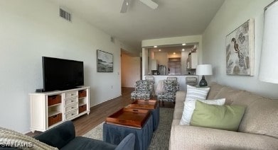 living area featuring visible vents, ceiling fan, and wood finished floors