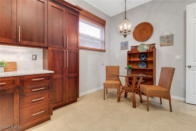 dining room featuring a chandelier and baseboards