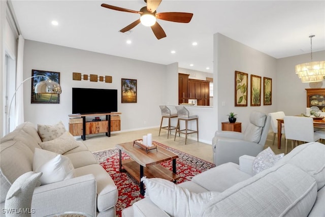 living area featuring recessed lighting, baseboards, and ceiling fan with notable chandelier