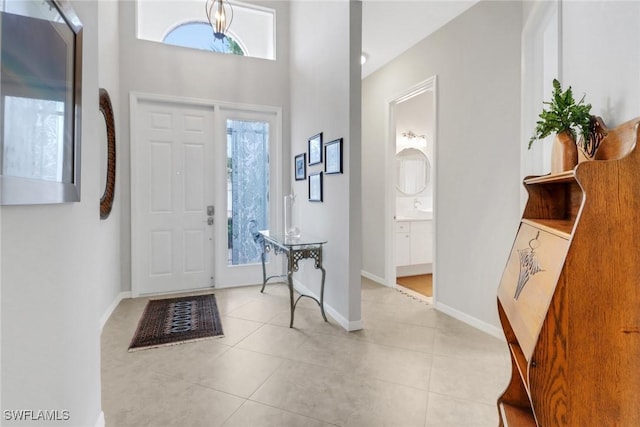 foyer entrance with light tile patterned floors, baseboards, and a healthy amount of sunlight