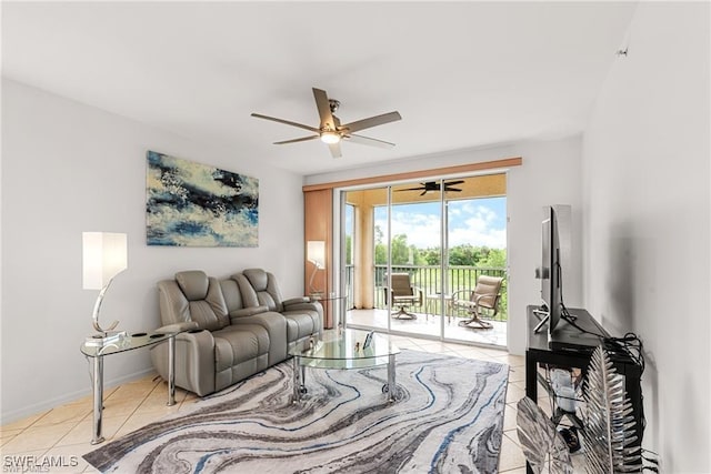 living area featuring ceiling fan, baseboards, and light tile patterned floors