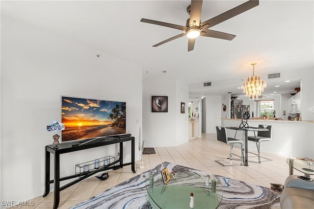 living room featuring ceiling fan with notable chandelier, visible vents, and light tile patterned flooring