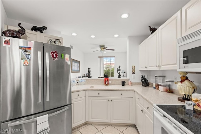 kitchen featuring white appliances, light tile patterned flooring, light countertops, white cabinetry, and recessed lighting