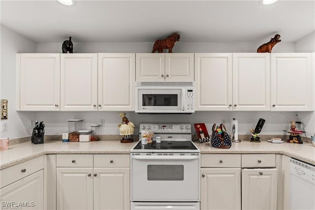 kitchen with light countertops, white appliances, and white cabinetry