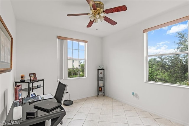 office area featuring light tile patterned floors, ceiling fan, a wealth of natural light, and baseboards