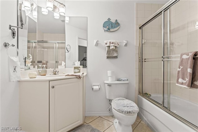 bathroom featuring enclosed tub / shower combo, vanity, toilet, and tile patterned floors