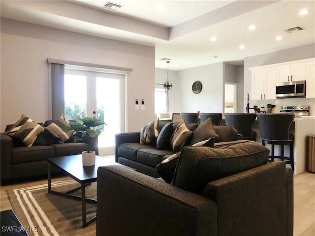 living room featuring recessed lighting, visible vents, and light wood finished floors